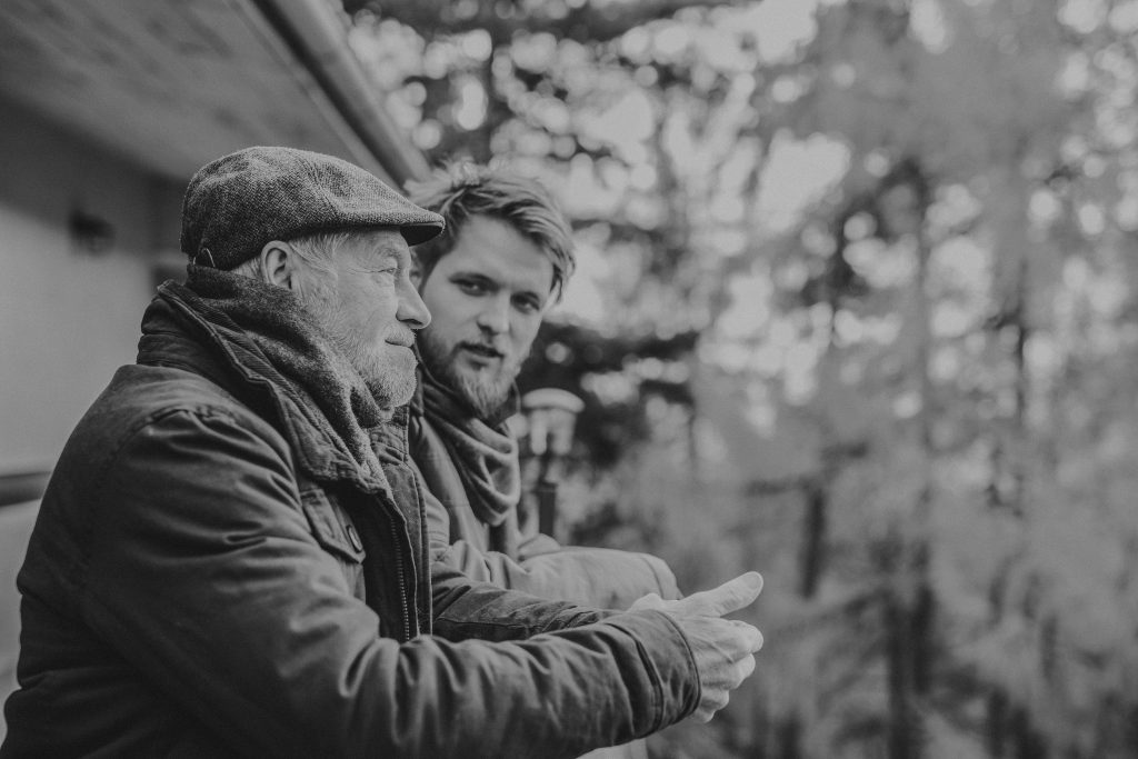 Senior father and his young son on a walk in town.